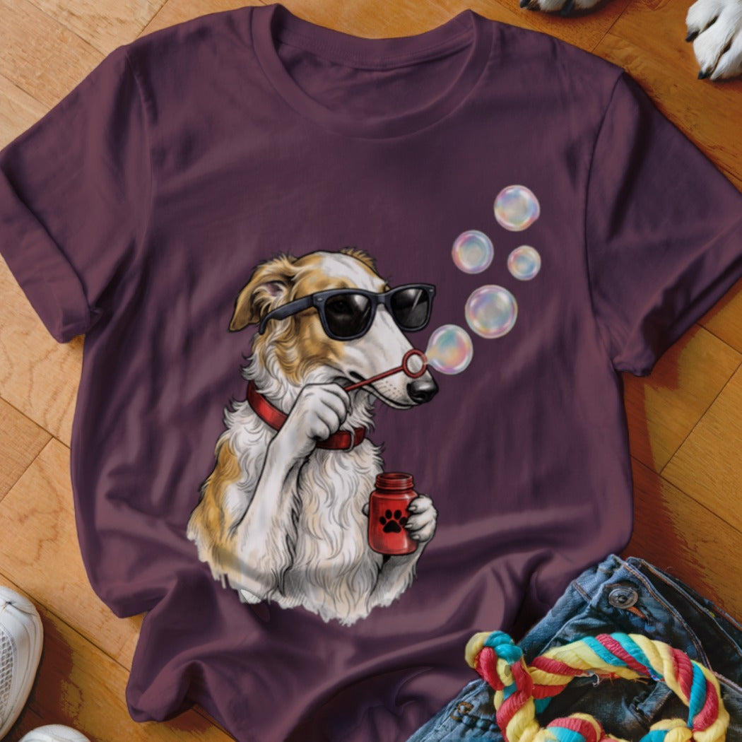 A plum-colored t-shirt featuring a graphic of a dog wearing sunglasses and blowing soap bubbles.