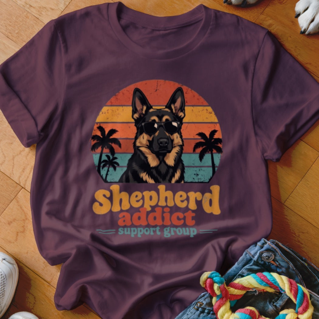 Maroon t-shirt featuring a retro sunset graphic with a German Shepherd wearing sunglasses and the text Shepherd addict support group.