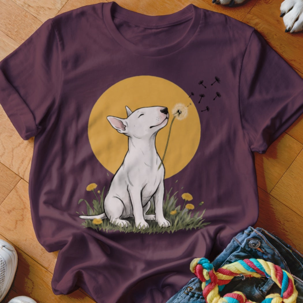 A maroon short-sleeved t-shirt featuring a graphic of a white Bull Terrier blowing dandelion seeds.