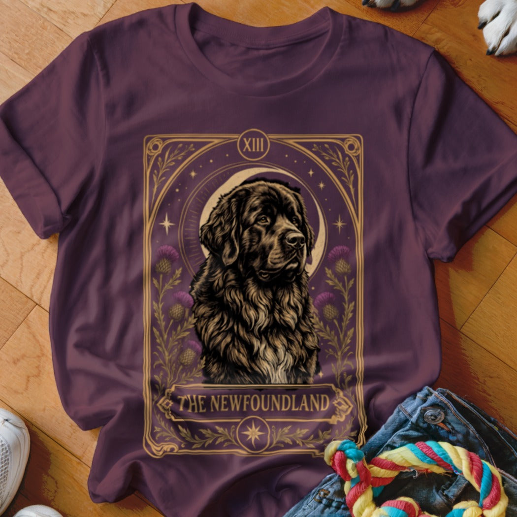 A dark plum t-shirt featuring a tarot-style graphic of a Newfoundland dog and thistle flowers.