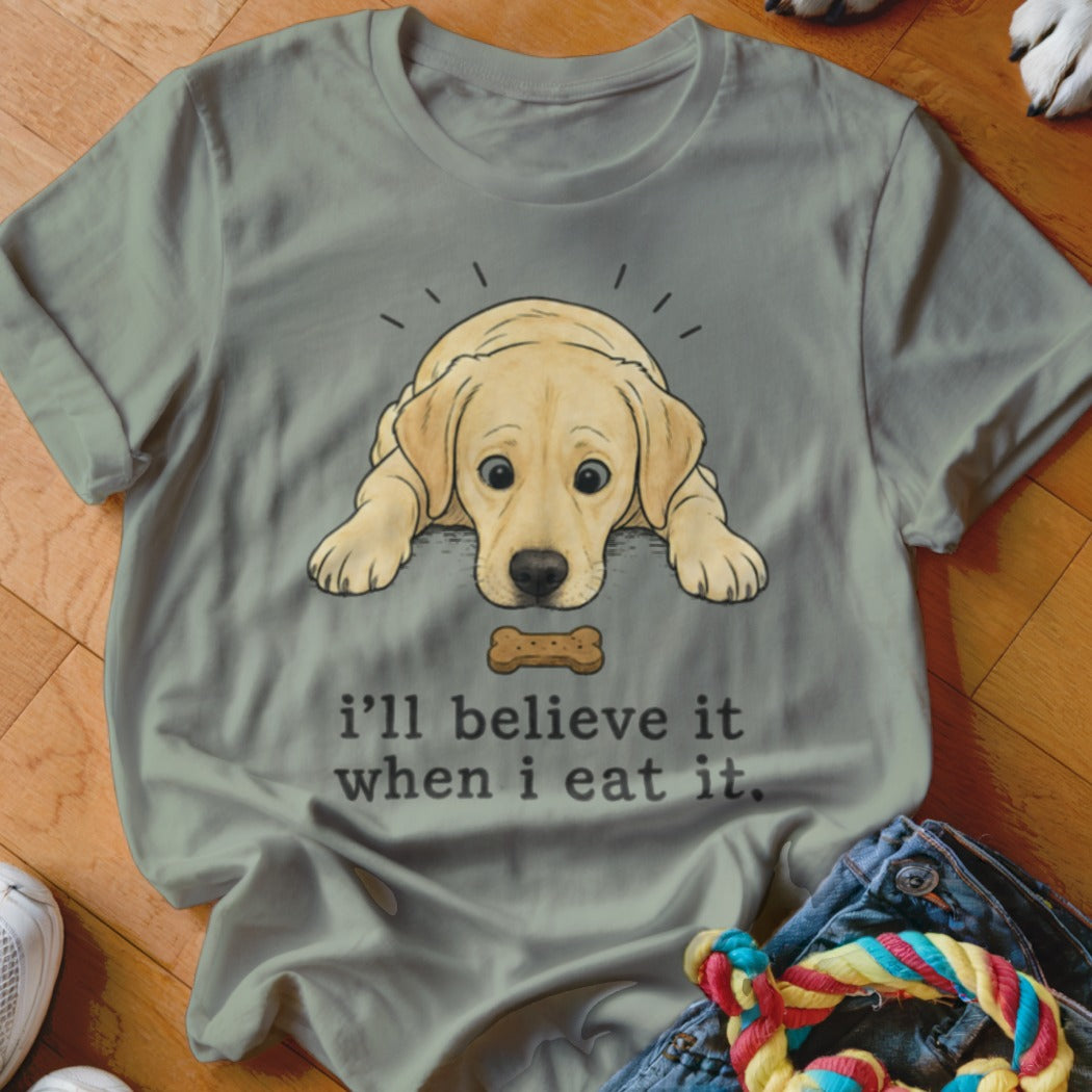 Grey t-shirt with a yellow labrador puppy graphic and text that reads "I'll believe it when I eat it."