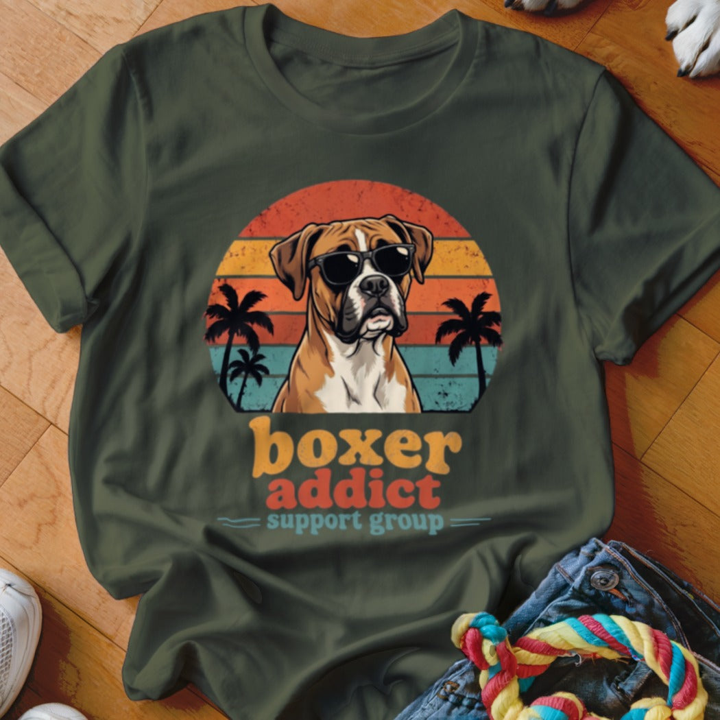 Olive green t-shirt with a vintage-style graphic of a Boxer dog wearing sunglasses, palm trees, and text reading boxer addict support group.
