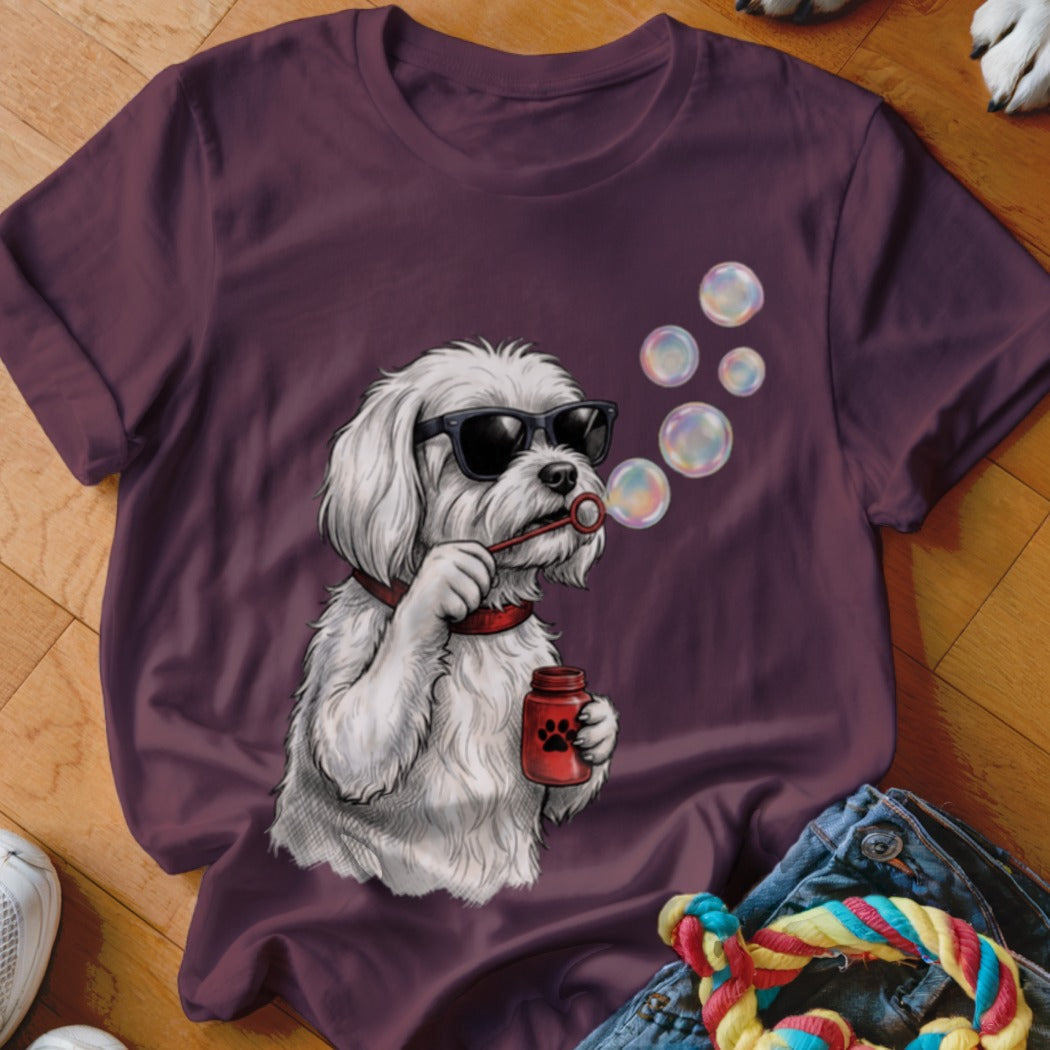 A dark purple t-shirt featuring a graphic of a white dog wearing sunglasses and blowing soap bubbles.