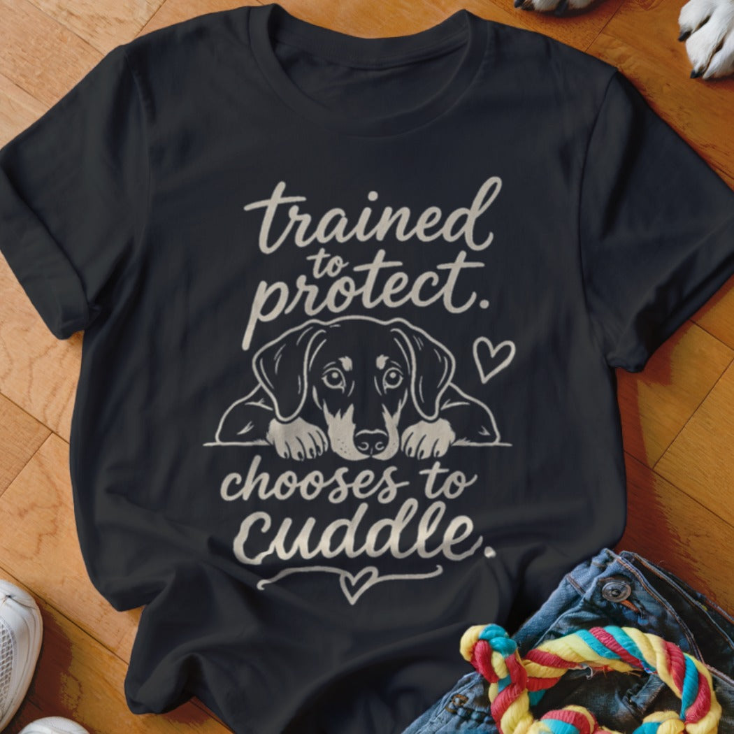 Black t-shirt with dog graphic and text "trained to protect, chooses to cuddle."