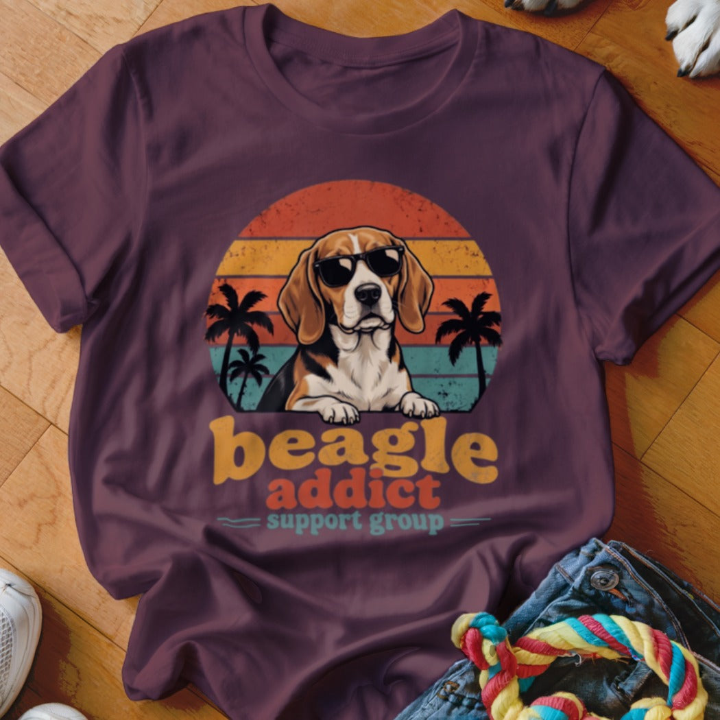 A maroon t-shirt with a retro sunset graphic, beagle wearing sunglasses, and text reading beagle addict support group.
