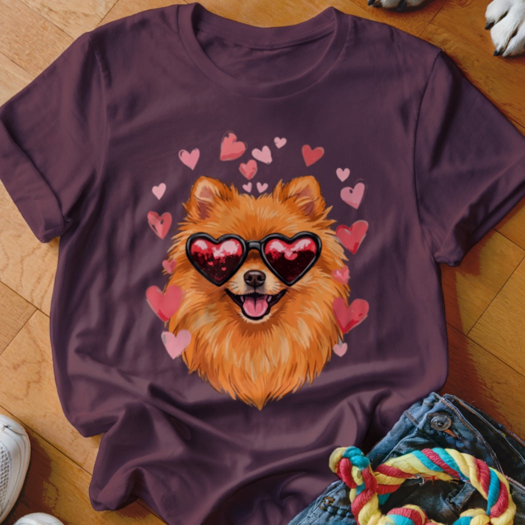 Dark purple t-shirt featuring a graphic of a Pomeranian wearing heart-shaped sunglasses surrounded by pink hearts.
