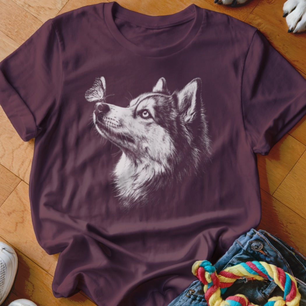 Maroon short-sleeved t-shirt featuring a white sketch graphic of a husky looking at a butterfly.