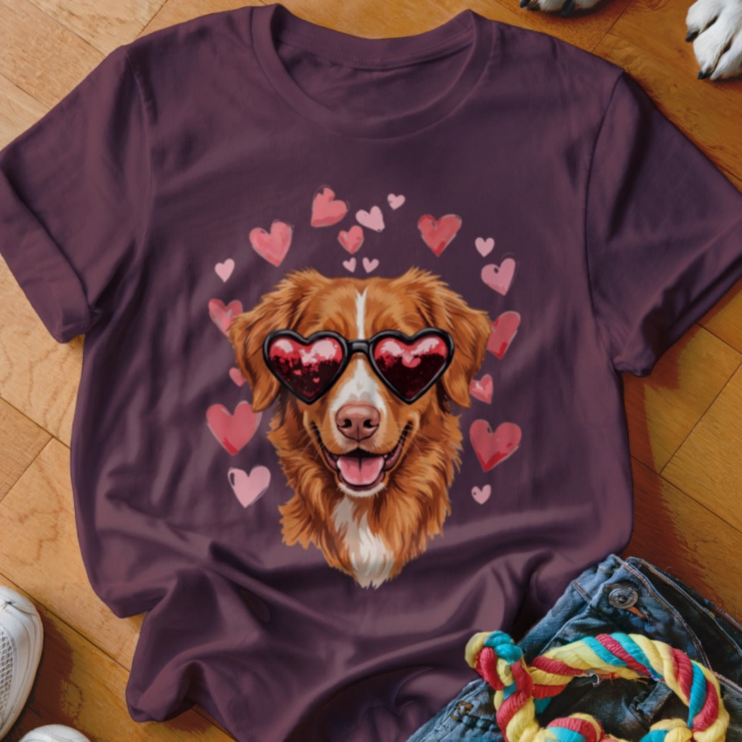 A dark purple t-shirt featuring a graphic of a golden dog wearing heart-shaped sunglasses, surrounded by pink hearts.