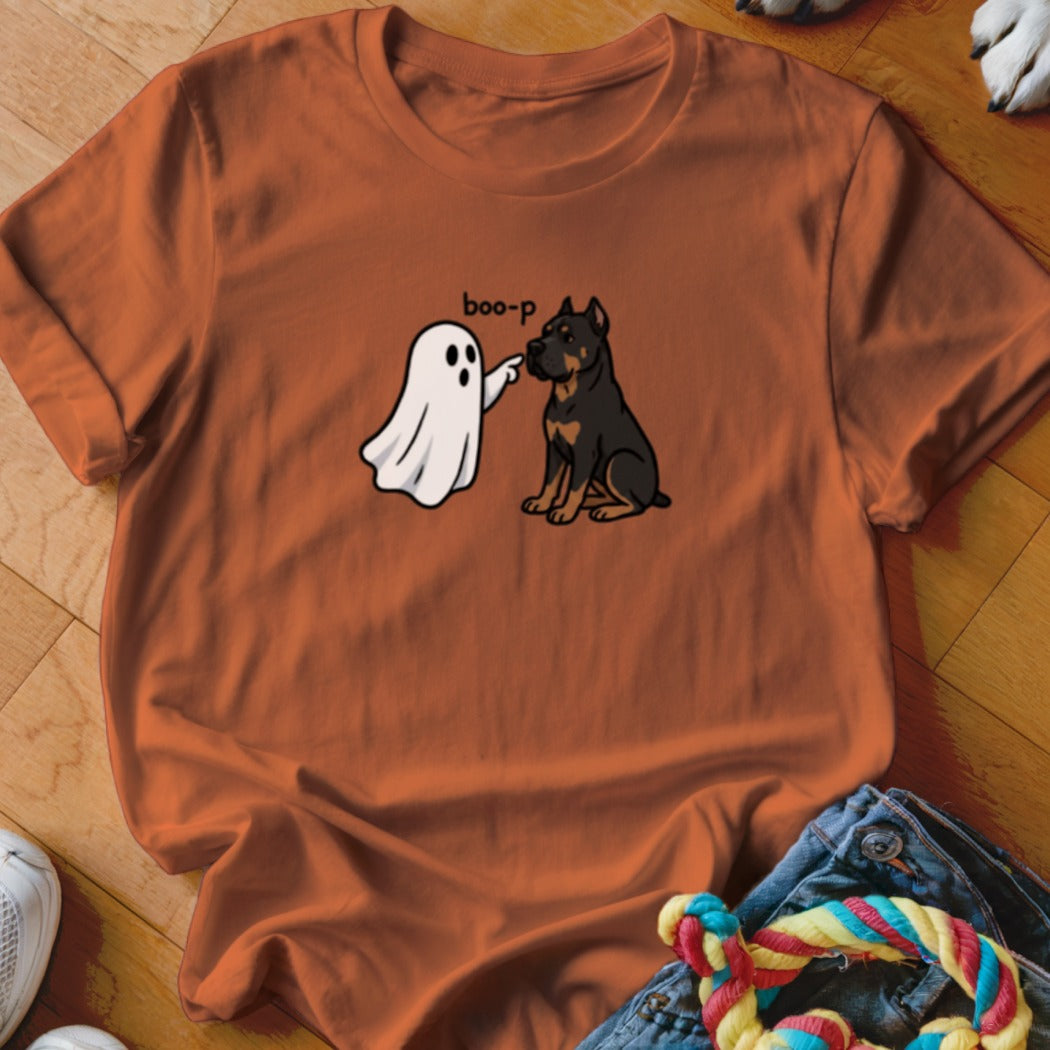 Cartoon ghost booping a Rottweiler with "boo-p" text on an orange t-shirt.