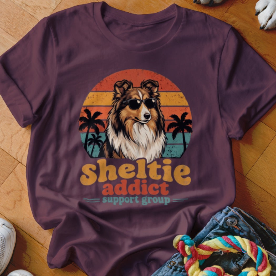 Maroon crewneck t-shirt featuring a retro graphic of a Sheltie wearing sunglasses in front of a sunset.