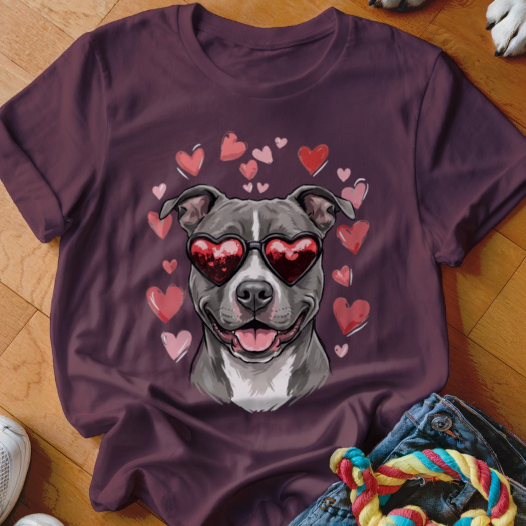 A dark purple t-shirt featuring a graphic of a gray pit bull wearing heart-shaped sunglasses, surrounded by pink hearts.