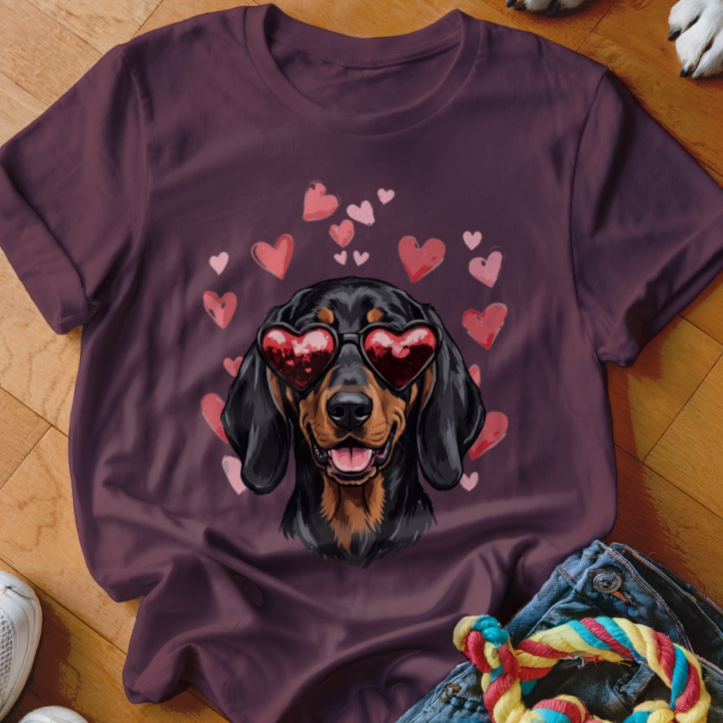 Maroon t-shirt featuring a graphic of a black and tan dachshund wearing heart-shaped sunglasses surrounded by pink hearts.