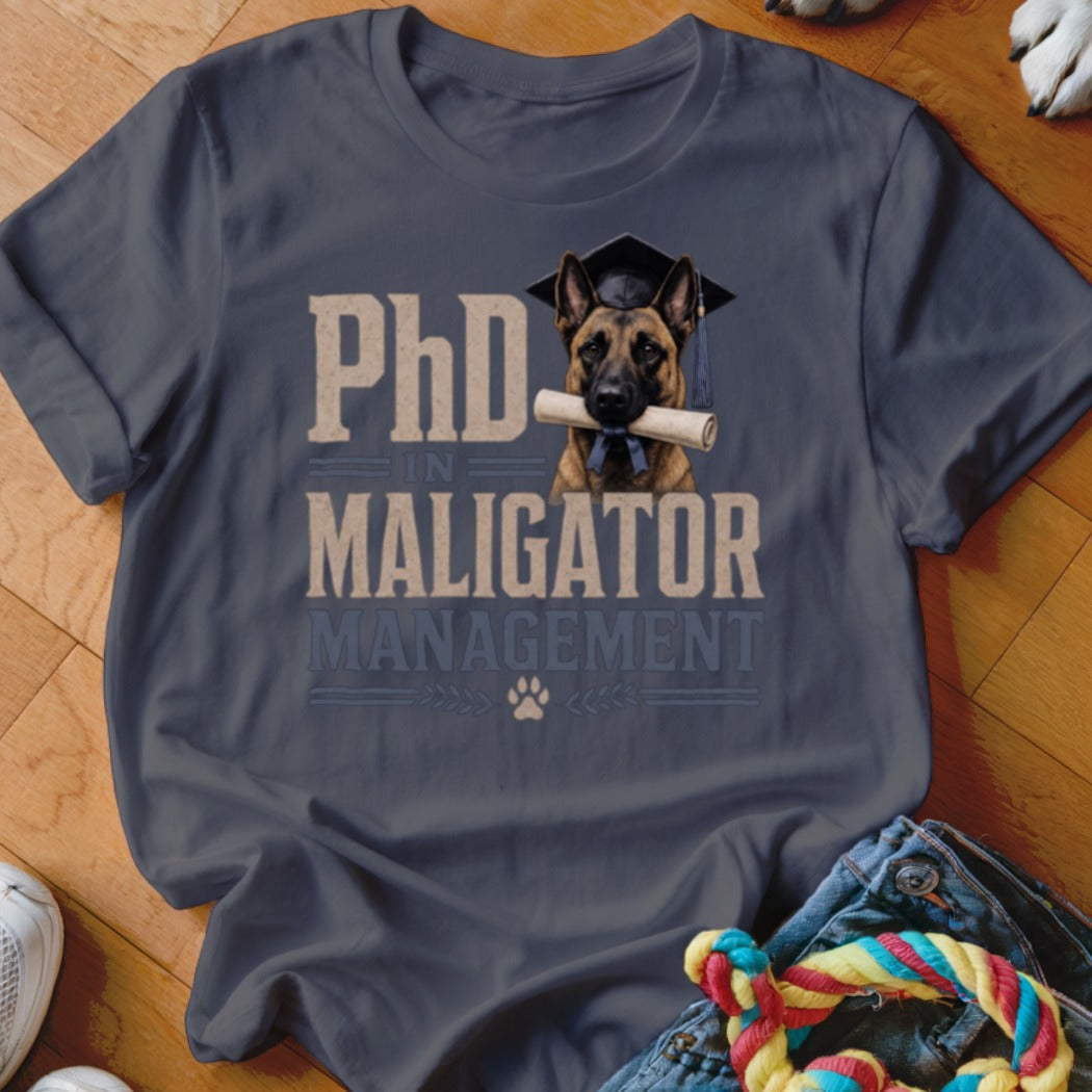 T-shirt design: dog with graduation cap and diploma, reads "PhD in Maligator Management."