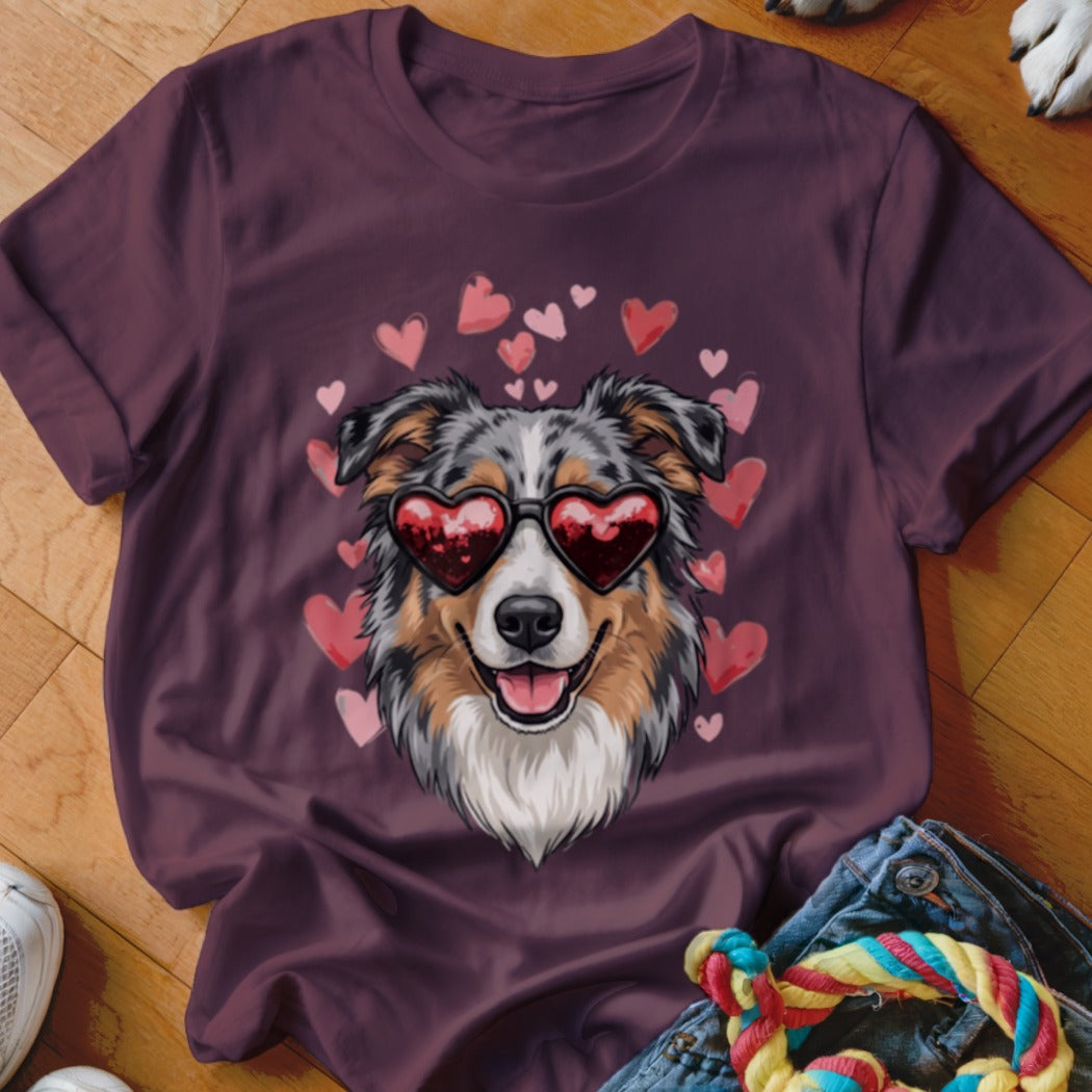 Maroon t-shirt featuring a graphic of an Australian Shepherd wearing heart-shaped sunglasses surrounded by pink hearts.