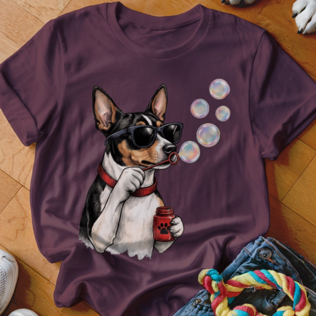 A maroon t-shirt featuring a graphic of a black and white dog wearing sunglasses and blowing bubbles.