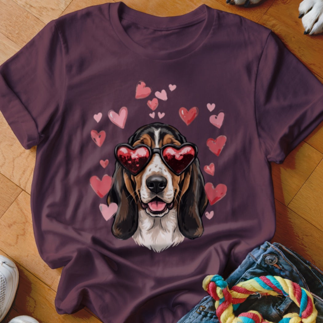 Dark purple t-shirt featuring a graphic of a basset hound wearing heart-shaped sunglasses surrounded by pink hearts.