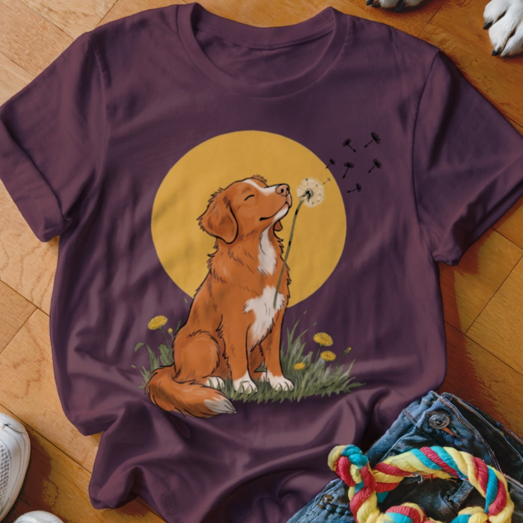 A dark purple t-shirt features a graphic of a brown dog sitting and blowing dandelion seeds.