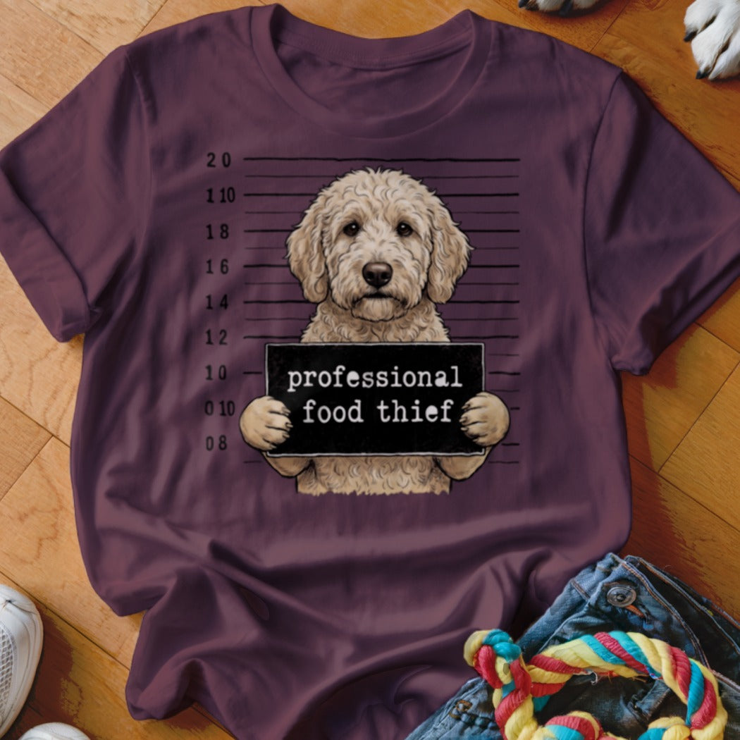 Goldendoodle mugshot with "professional food thief" sign.