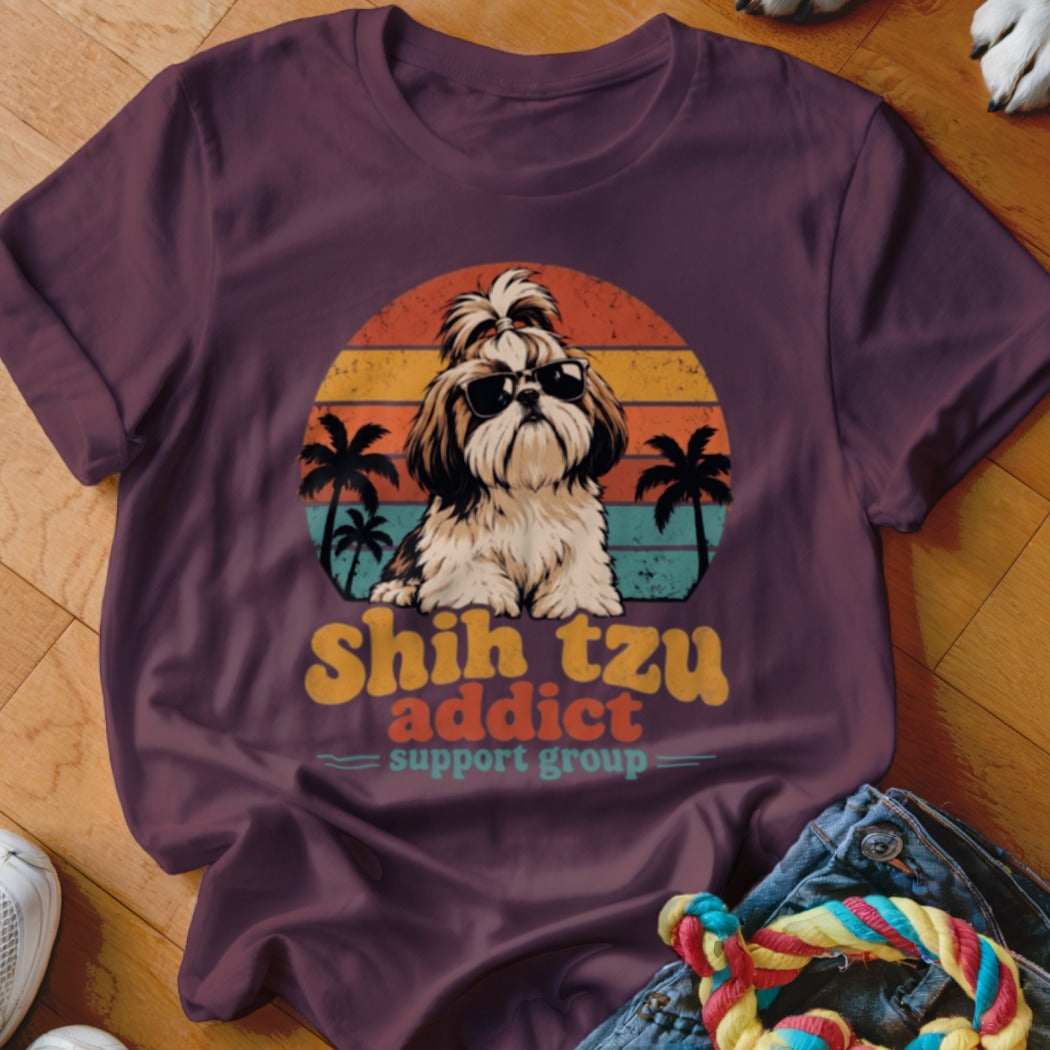 A dark purple t-shirt features a graphic of a Shih Tzu wearing sunglasses before a sunset and palm trees, with the text "Shih Tzu addict support group."
