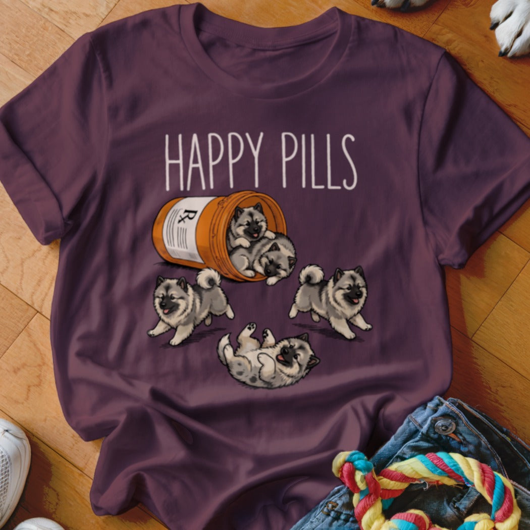 T-shirt with "Happy Pills" text and playful Keeshond puppies spilling from a pill bottle.