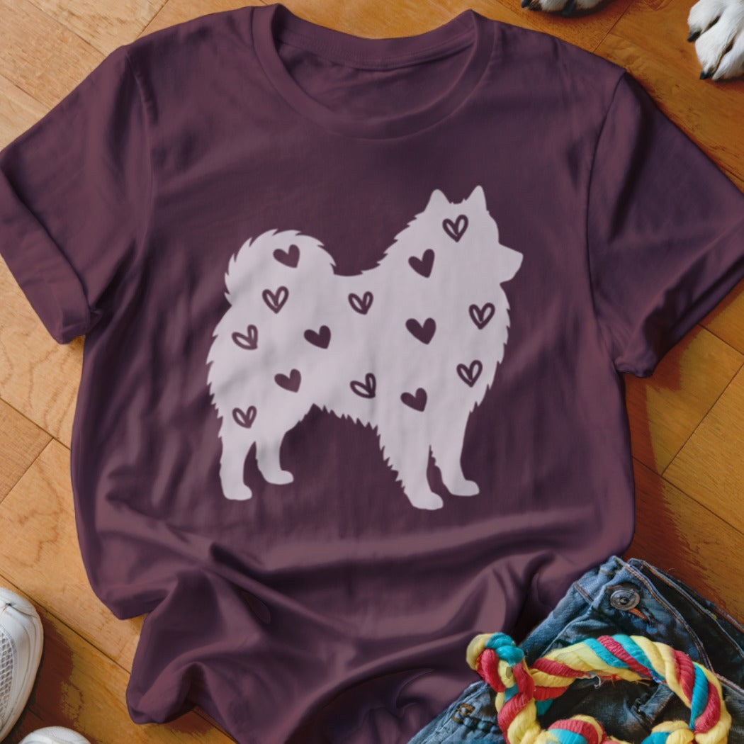 Maroon t-shirt with a white silhouette of a fluffy dog covered in small hearts.