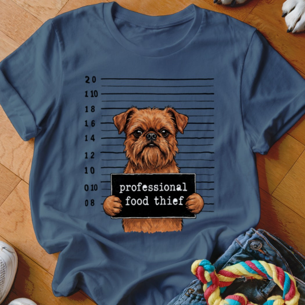 Brown dog with "professional food thief" sign in mugshot background.
