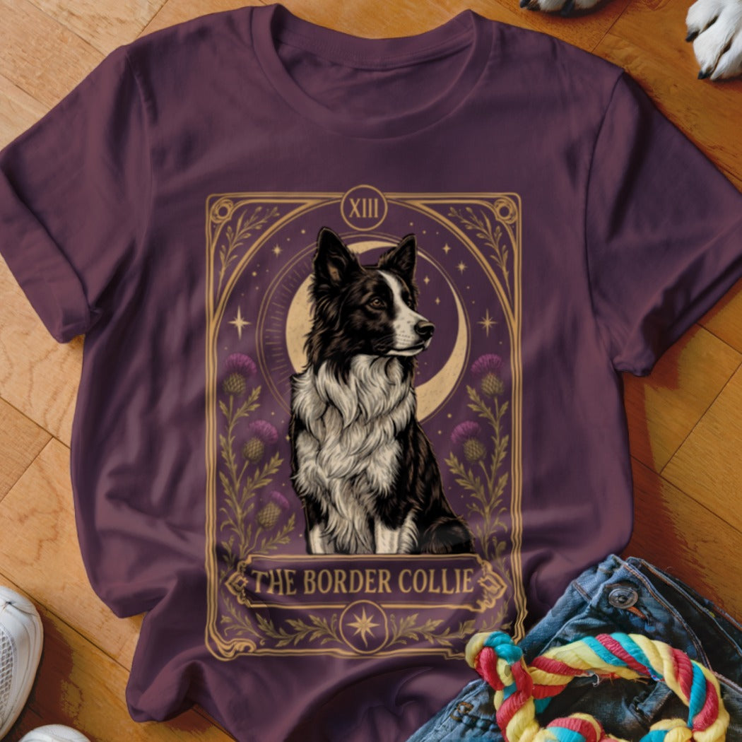 Plum-colored t-shirt featuring a tarot card graphic of a Border Collie, crescent moon, and thistles.