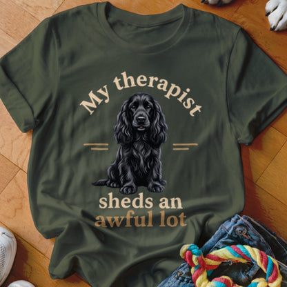 Olive green t-shirt with black dog graphic and "My therapist sheds an awful lot" text.