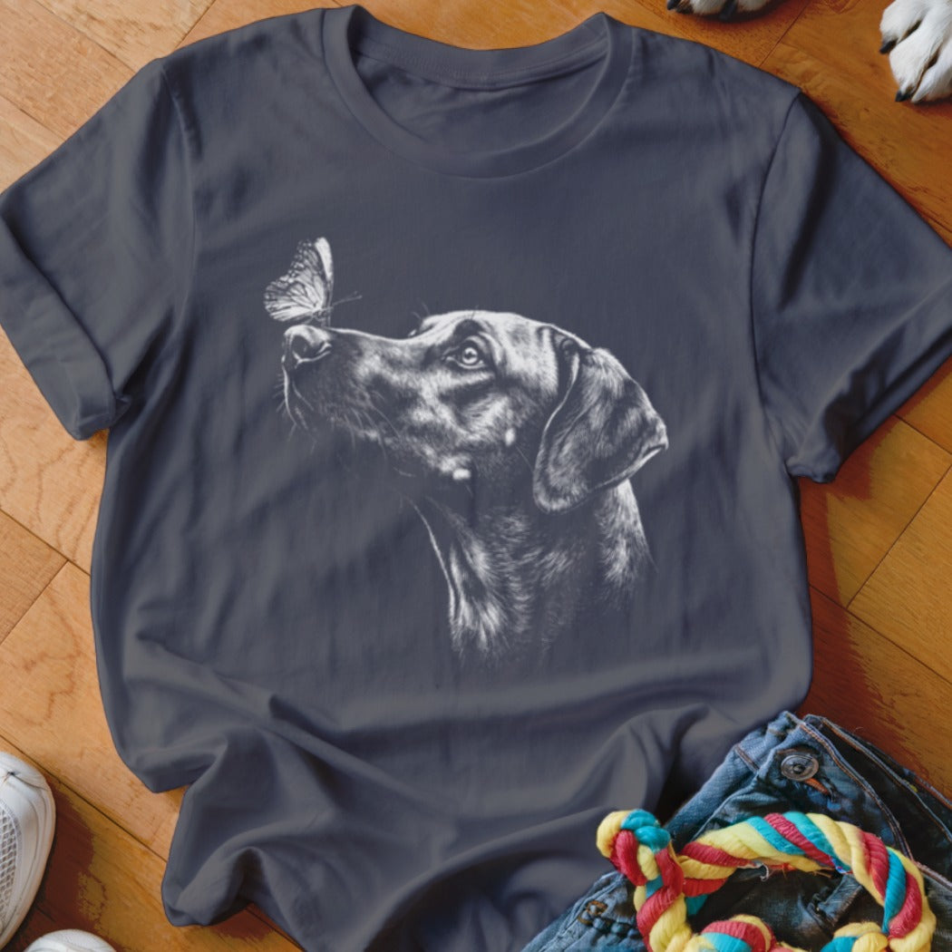 A dark gray t-shirt featuring a white sketch graphic of a dog looking at a butterfly.