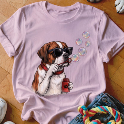 A pink t-shirt featuring a graphic of a Saint Bernard dog wearing sunglasses and blowing bubbles.
