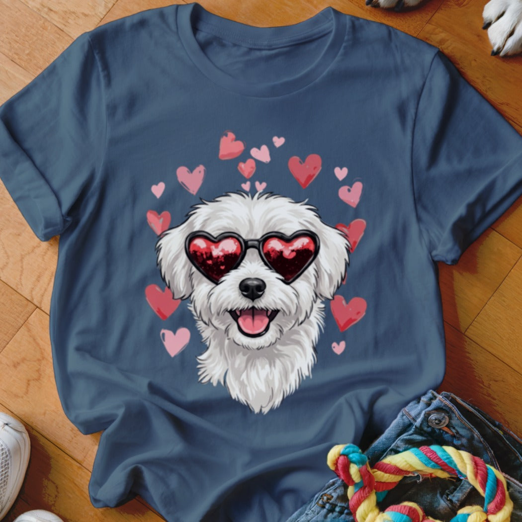 A dark blue t-shirt printed with a fluffy white dog wearing heart-shaped sunglasses, surrounded by pink hearts.