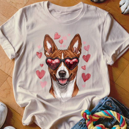 A light beige t-shirt featuring a graphic of a brown and white dog wearing heart-shaped sunglasses, surrounded by pink hearts.