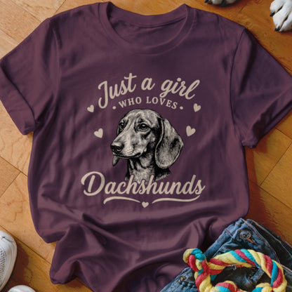 A maroon t-shirt with a dachshund graphic and text reading Just a girl who loves Dachshunds.