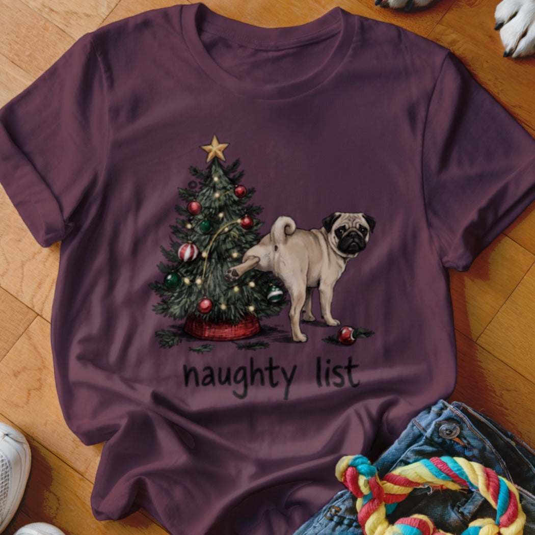 A dark purple crewneck t-shirt featuring a pug lifting its leg on a Christmas tree with the text naughty list.