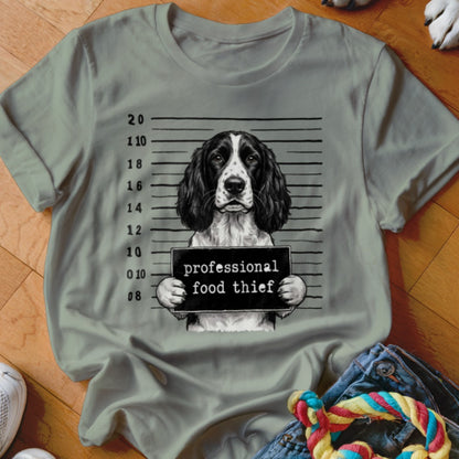 Springer Spaniel in mugshot holding "professional food thief" sign with height chart.