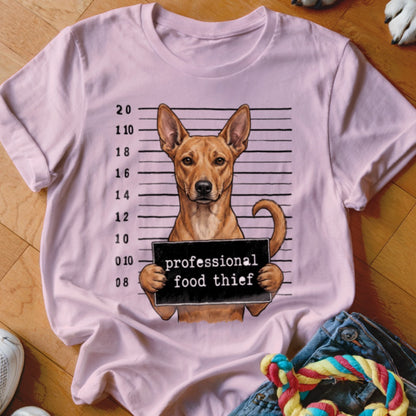 Dog mugshot with text "professional food thief" on a pink t-shirt.