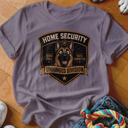 Grey t-shirt with a shield graphic featuring a German Shepherd dog, "Home Security," "Zero Chill," "100% Committed," and "Unhinged Division."