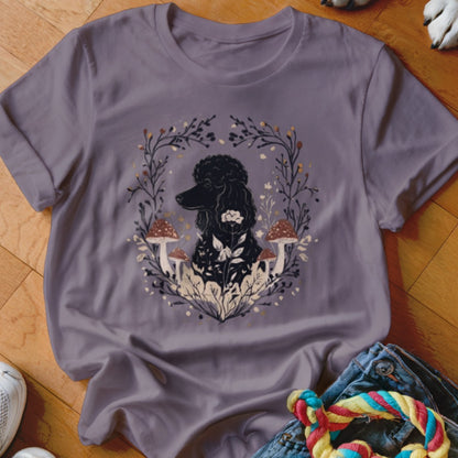 A dusty purple crewneck t-shirt featuring a graphic of a black poodle surrounded by mushrooms and foliage.