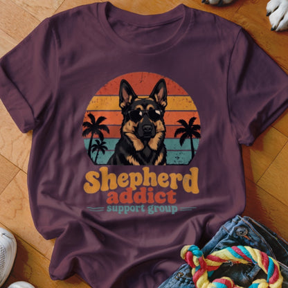 Maroon t-shirt featuring a retro sunset graphic with a German Shepherd wearing sunglasses and the text Shepherd addict support group.
