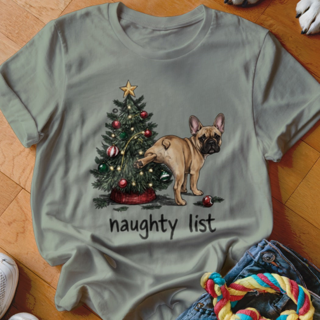 Sage green crewneck t-shirt featuring a French bulldog lifting its leg at a decorated Christmas tree above the text naughty list.