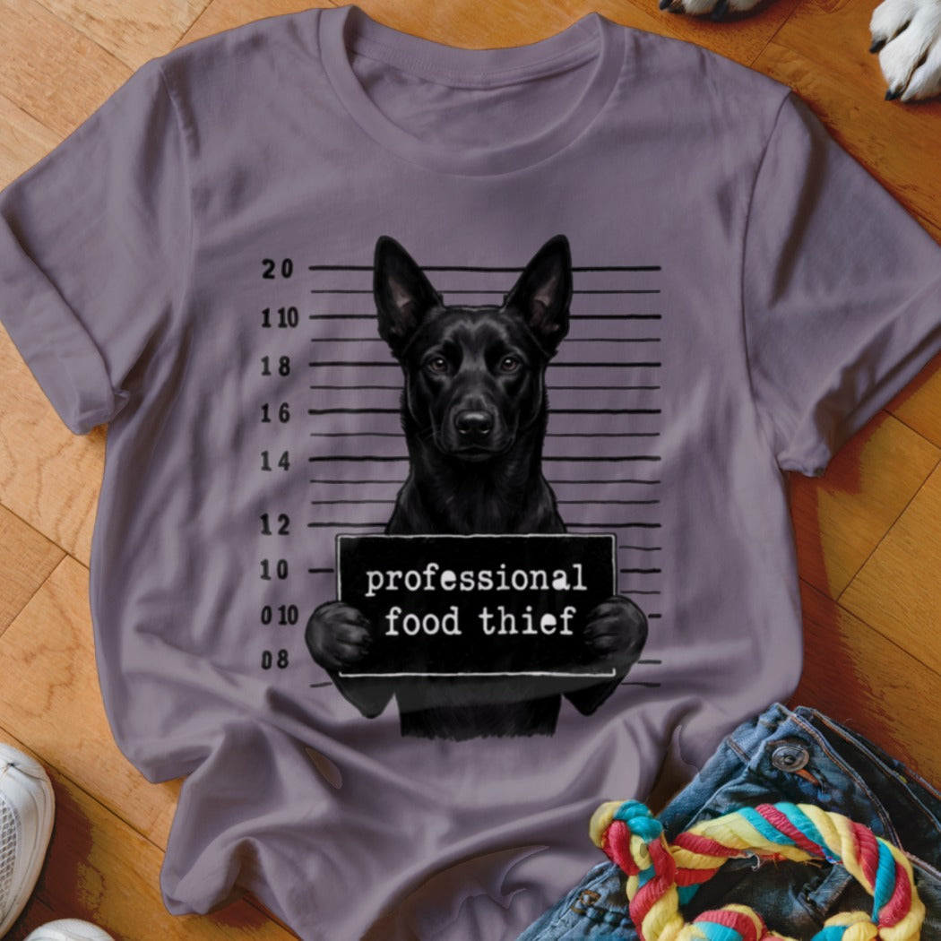 Black dog mugshot on t-shirt with "professional food thief" sign.