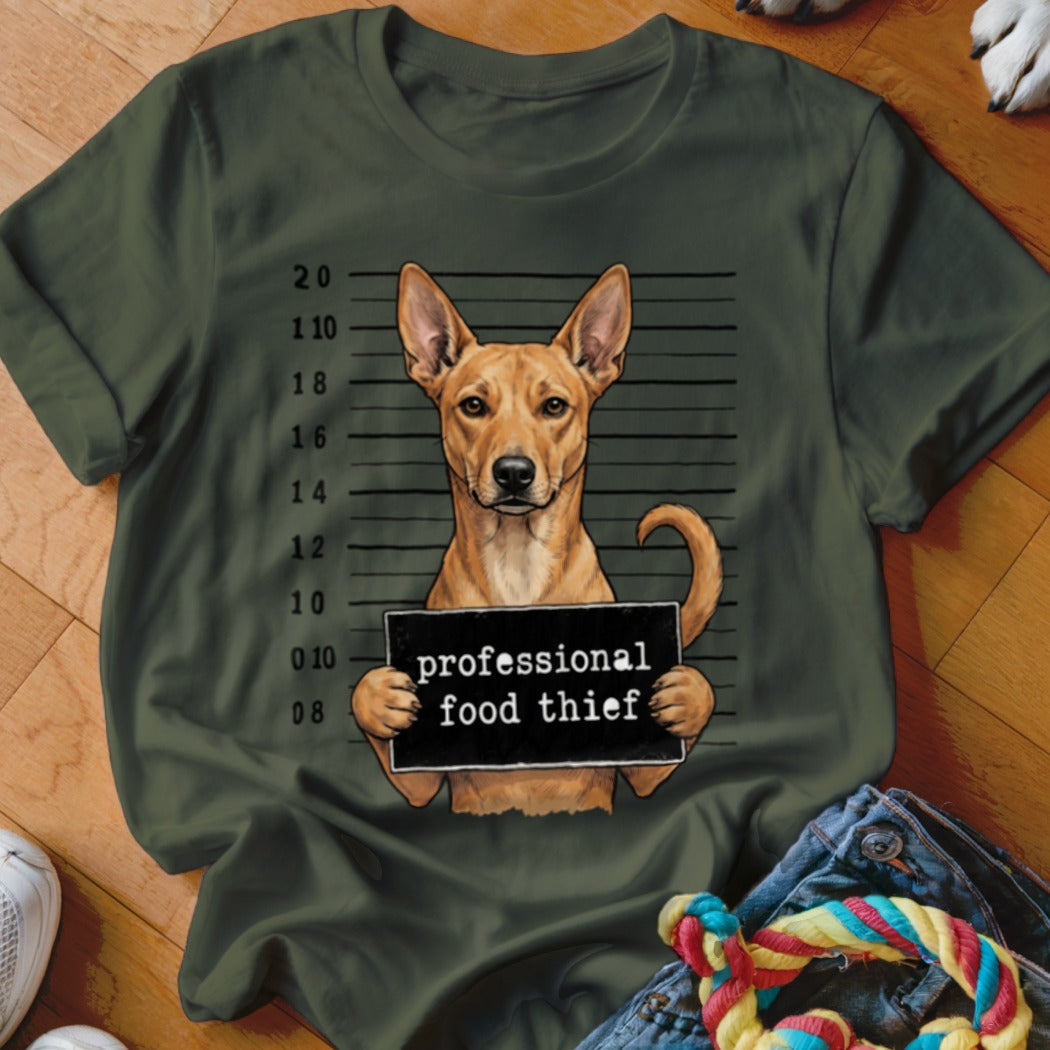 Dog in mugshot holding sign that says "professional food thief"