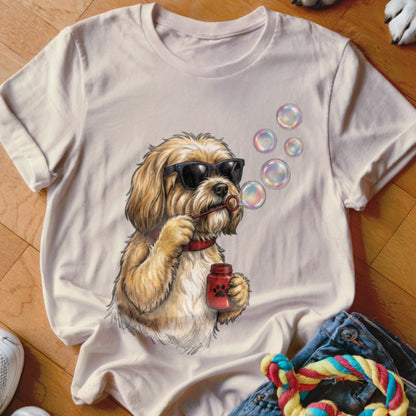 Beige t-shirt featuring a cartoon illustration of a fluffy dog wearing sunglasses and blowing bubbles.