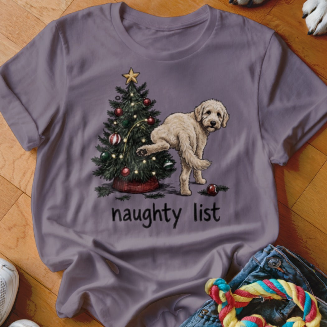 Light-colored dog lifting leg next to decorated Christmas tree with "naughty list" text.