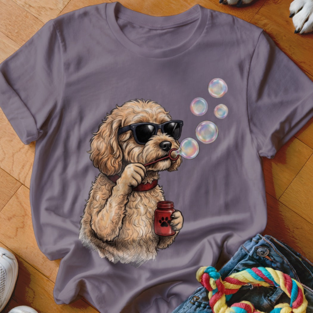 A purple t-shirt featuring a graphic of a fluffy dog wearing sunglasses and blowing bubbles.