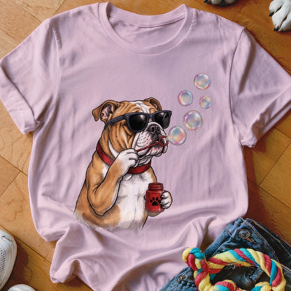 A pink t-shirt featuring a graphic of a bulldog wearing sunglasses and blowing soap bubbles.