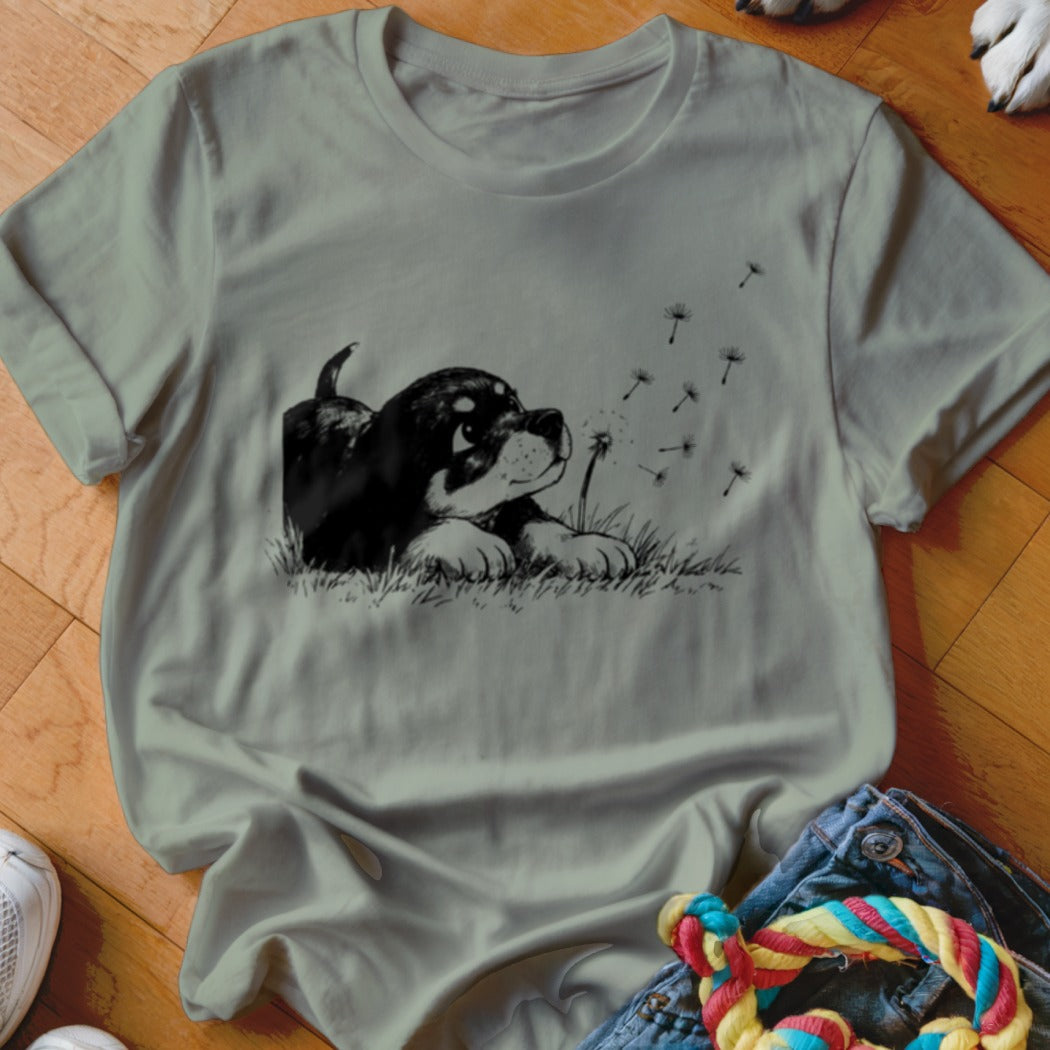 Sage green crewneck t-shirt featuring a black and white graphic of a puppy in grass.