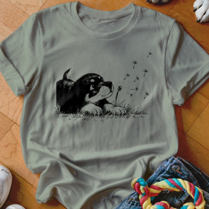 Sage green crewneck t-shirt featuring a black and white graphic of a puppy in grass.