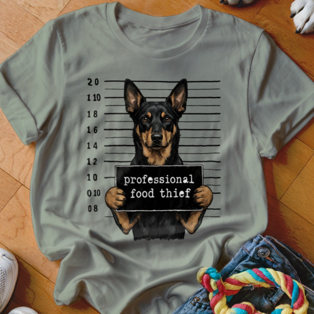 Dog in mugshot holding sign that says "professional food thief".