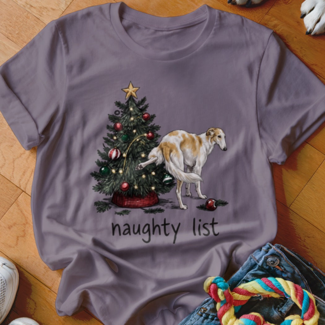 A grey t-shirt featuring a graphic of a dog lifting its leg on a Christmas tree with the text naughty list underneath.